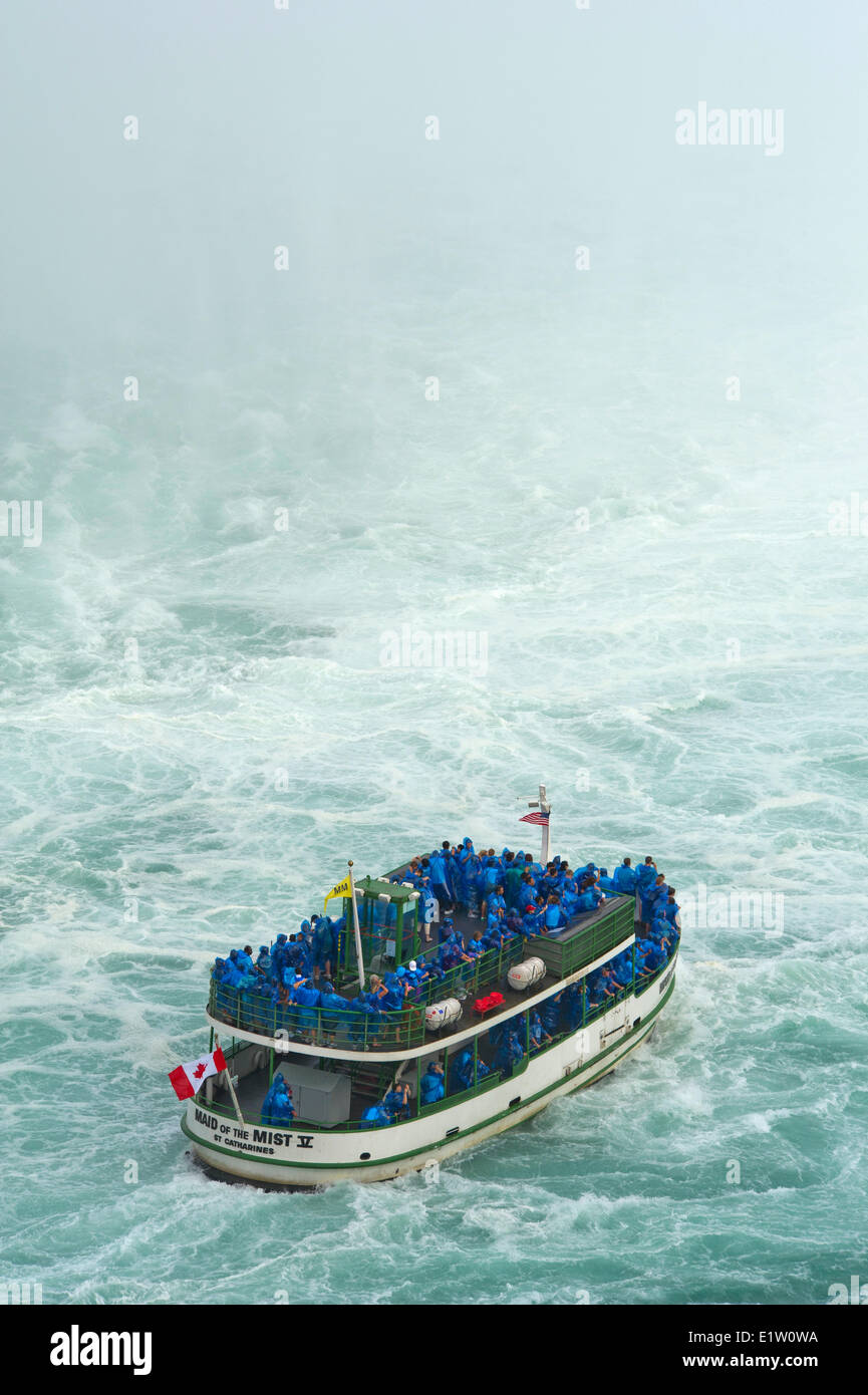 Maid of the Mist boat carrying tourists at the bottom of Niagara Falls Stock Photo