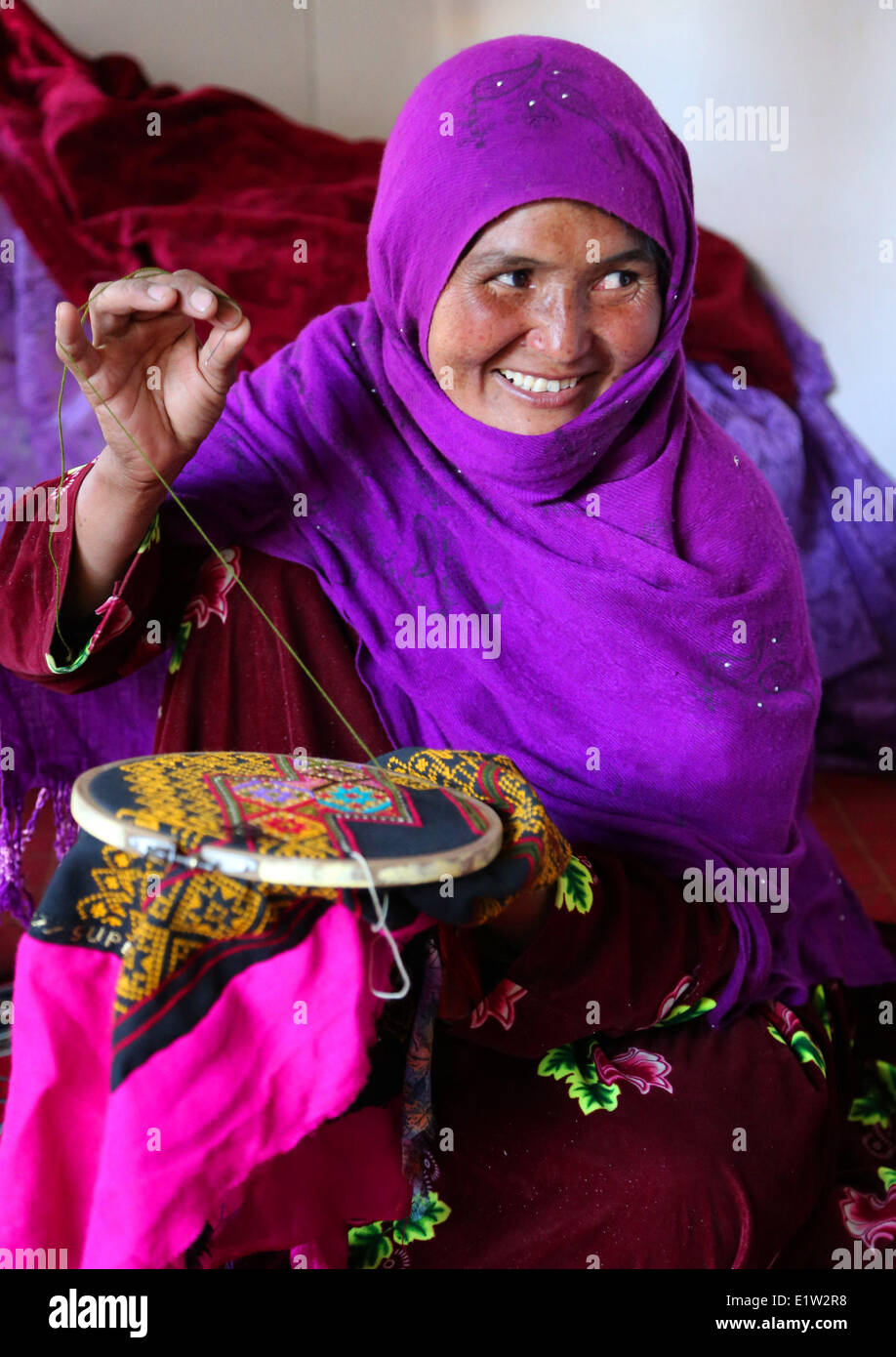 (140610) -- BAMYAN, June 10, 2 014.(Xinhua) -- An Afghan woman makes a traditional handicraft at a traditional dress-making factory in Bamyan province, Afghanistan, June 10, 2014. (Xinhua/Kamran) Stock Photo