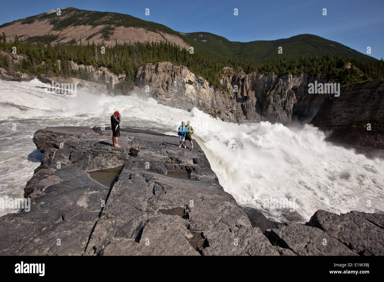 Family enjoy view at Sluicebox (son photographing parents), Virginia Falls, Nahanni National Park Preserve, NWT, Canada. Stock Photo