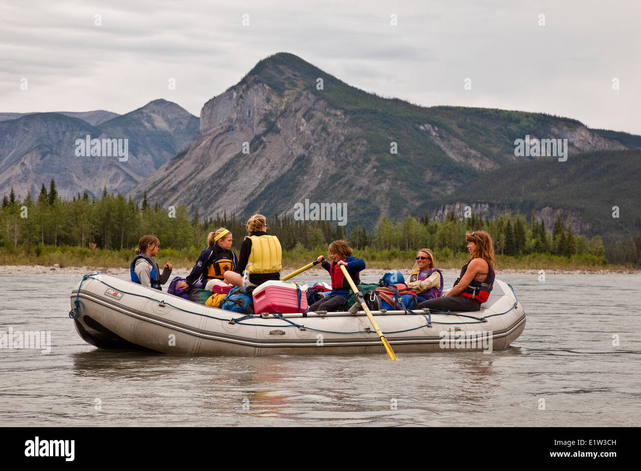 Young girl takes a turn on the oars of raft on Nahanni River, Nahanni National Park Preserve, NWT, Canada. Stock Photo