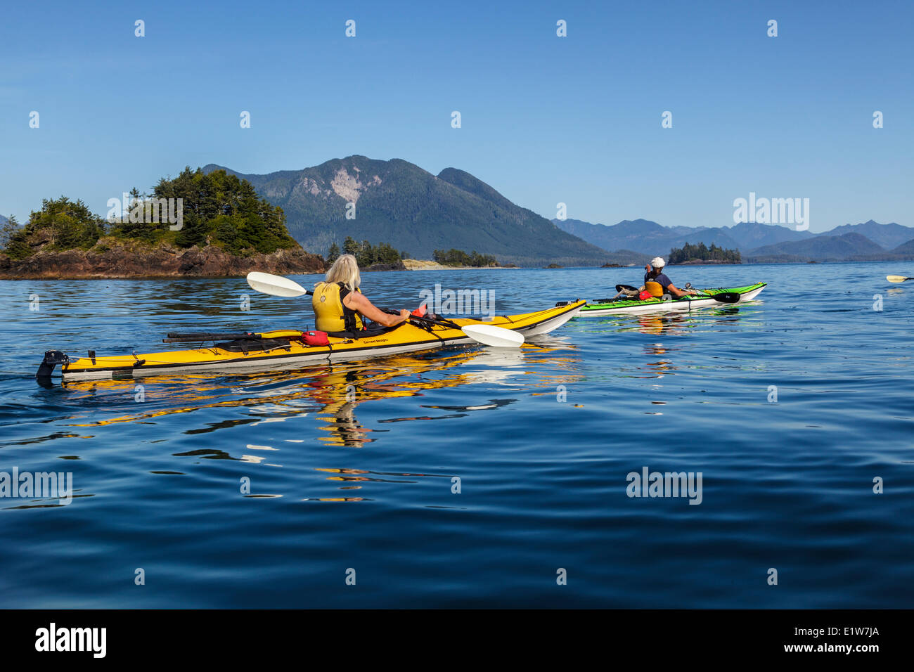 Two kayakers approach Whalers Islet in Clayoquot Sound off the west coast of Vancouver Island, British Columbia, Canada. Model R Stock Photo