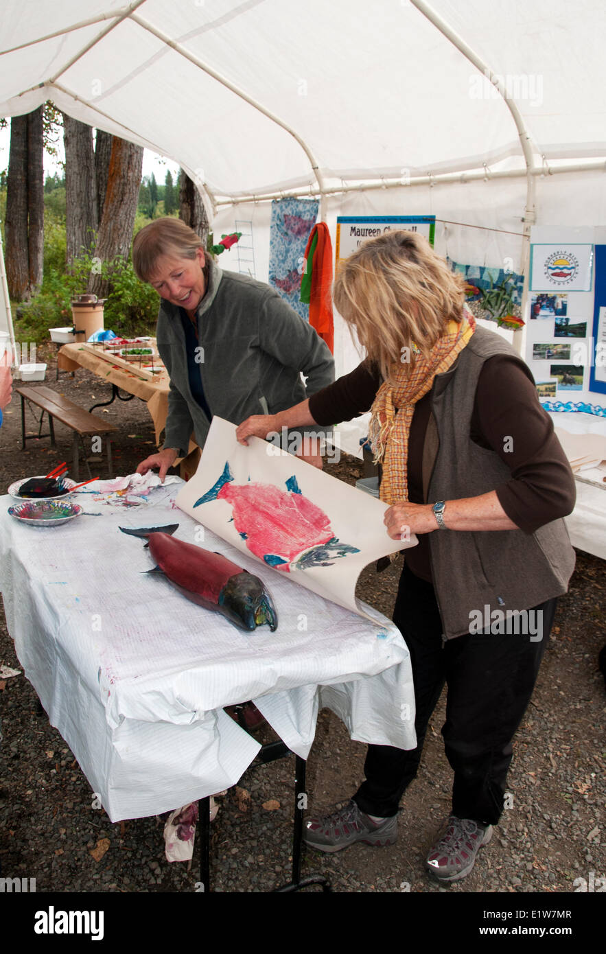 Women painting amd print making a salmon Japanese Gyotaku fish art print making at the Horsefly River Salmon Festival Sept. 2 Stock Photo