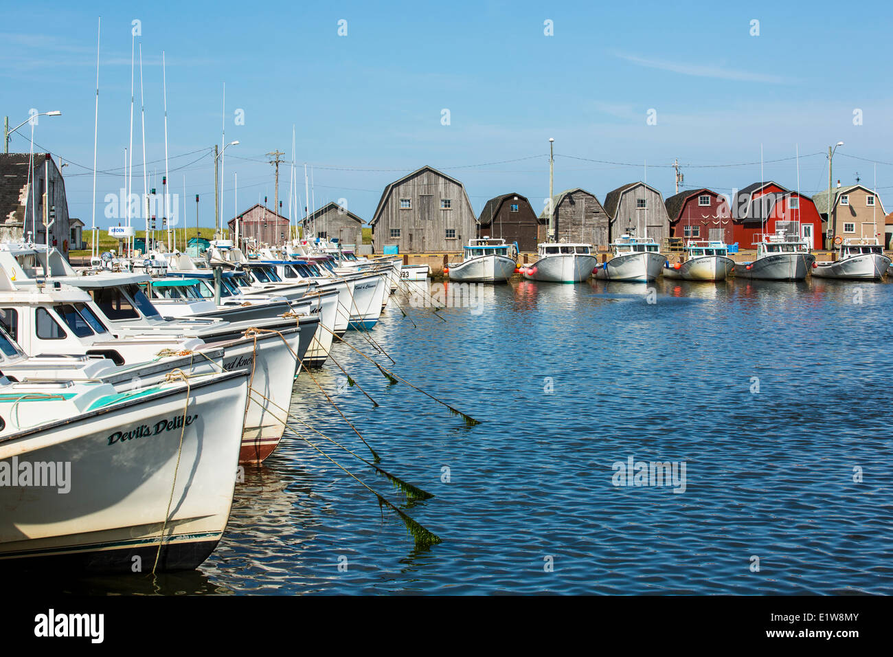 Fishing boats tied up at Malpeque Harbour wharf, Prince Edward Island, Canada Stock Photo