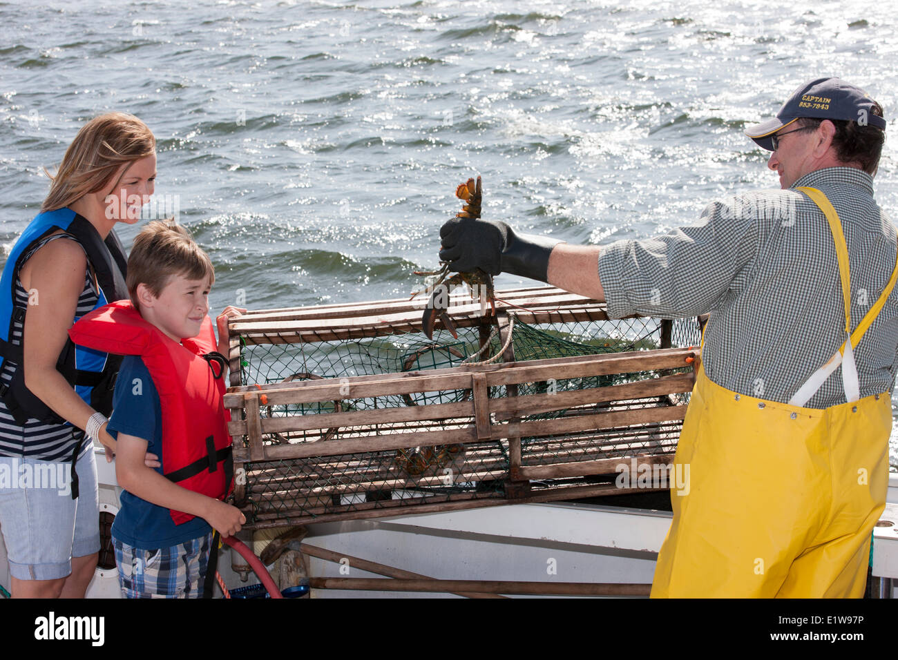 Young boy and mother  talking to Lobster fisherman, Northport, Prince Edward Island, Canada Stock Photo