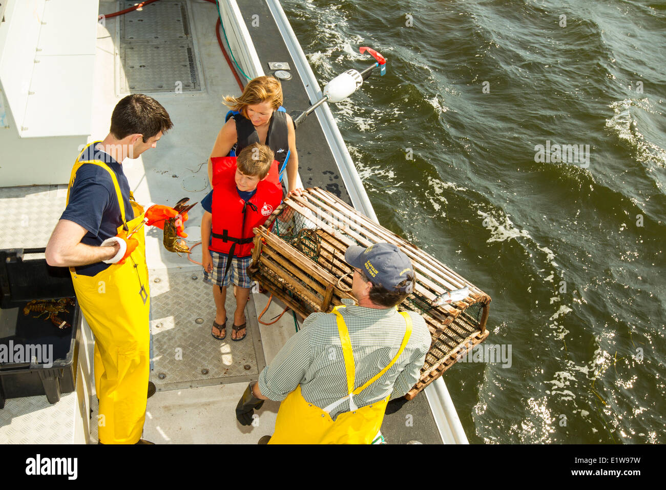 Young boy and mother  talking to Lobster fishermen, Northport, Prince Edward Island, Canada Stock Photo