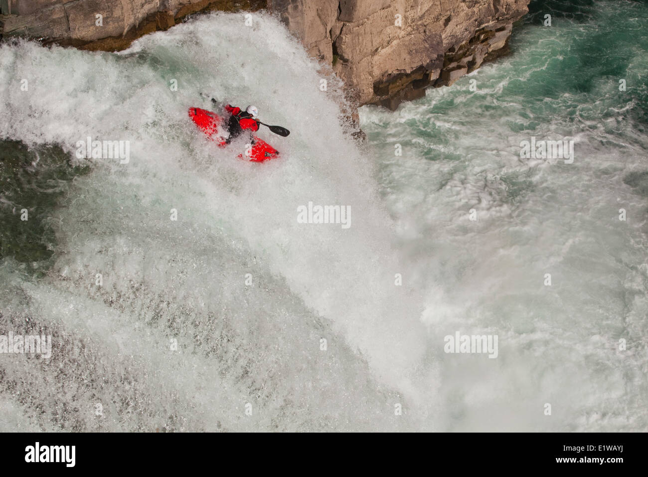 A male kayaker runs leap of faith, a 30 foot waterfall on the Upper Elk River, Fernie, BC Stock Photo