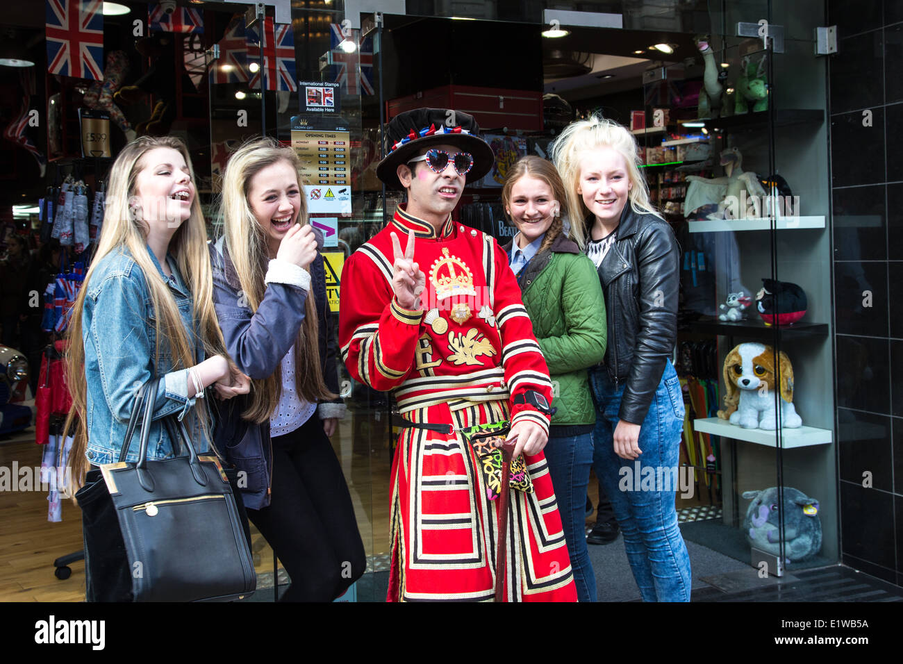 Shop Assistant dressed as a Beafeater poses for a photo with tourists, Piccadilly, London Stock Photo