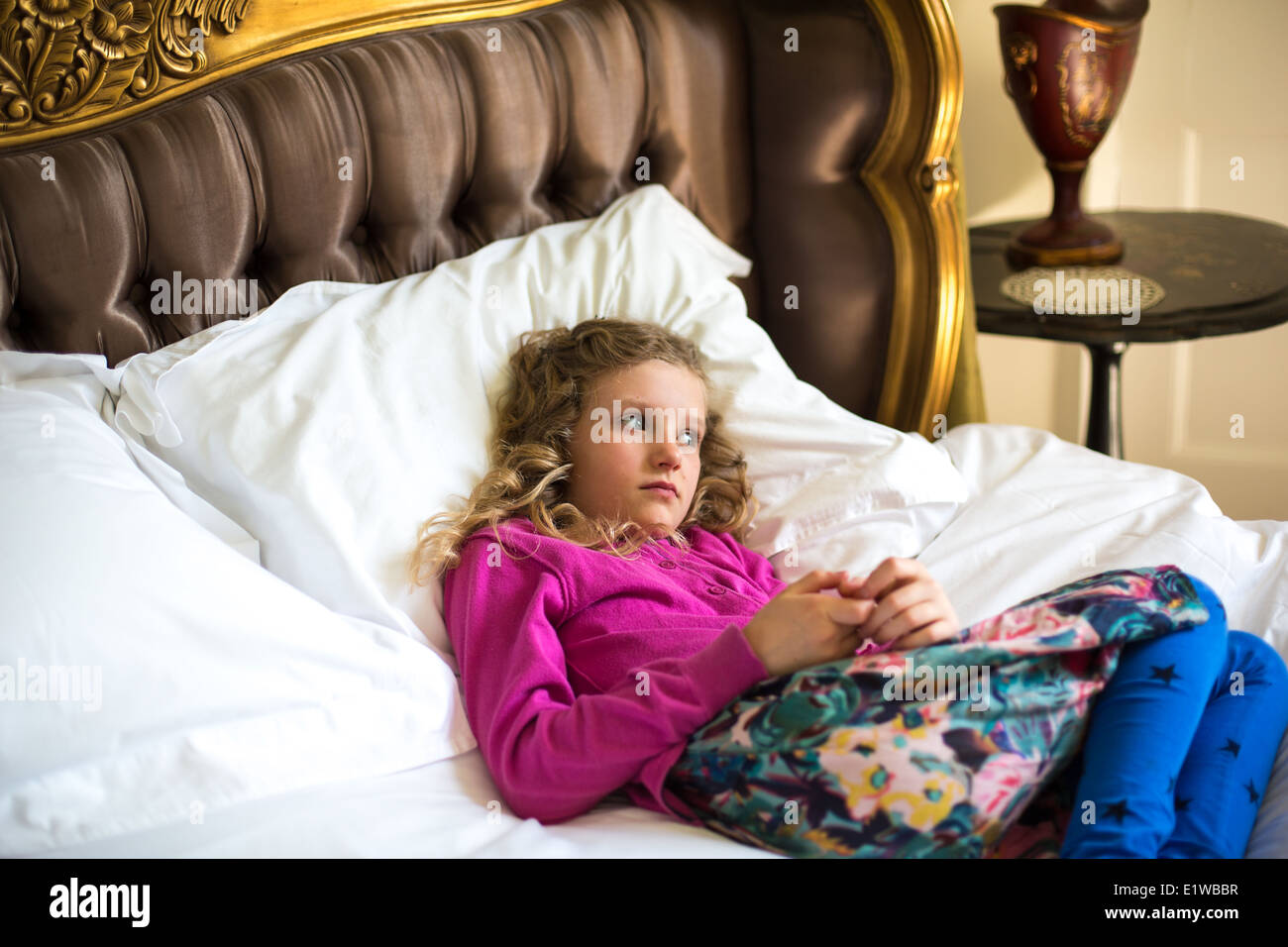 A young girl lying on a Bed Stock Photo
