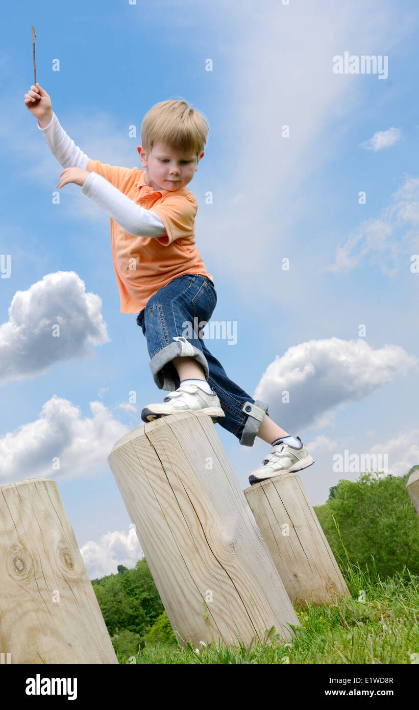 young boy learning to balance on stepping posts Stock Photo