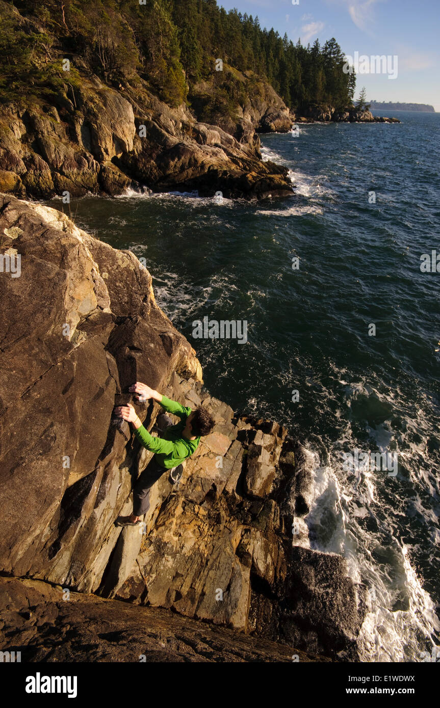 Rock climbing above the ocean at Lighthouse Park. West Vancouver, British Columbia, Canada Stock