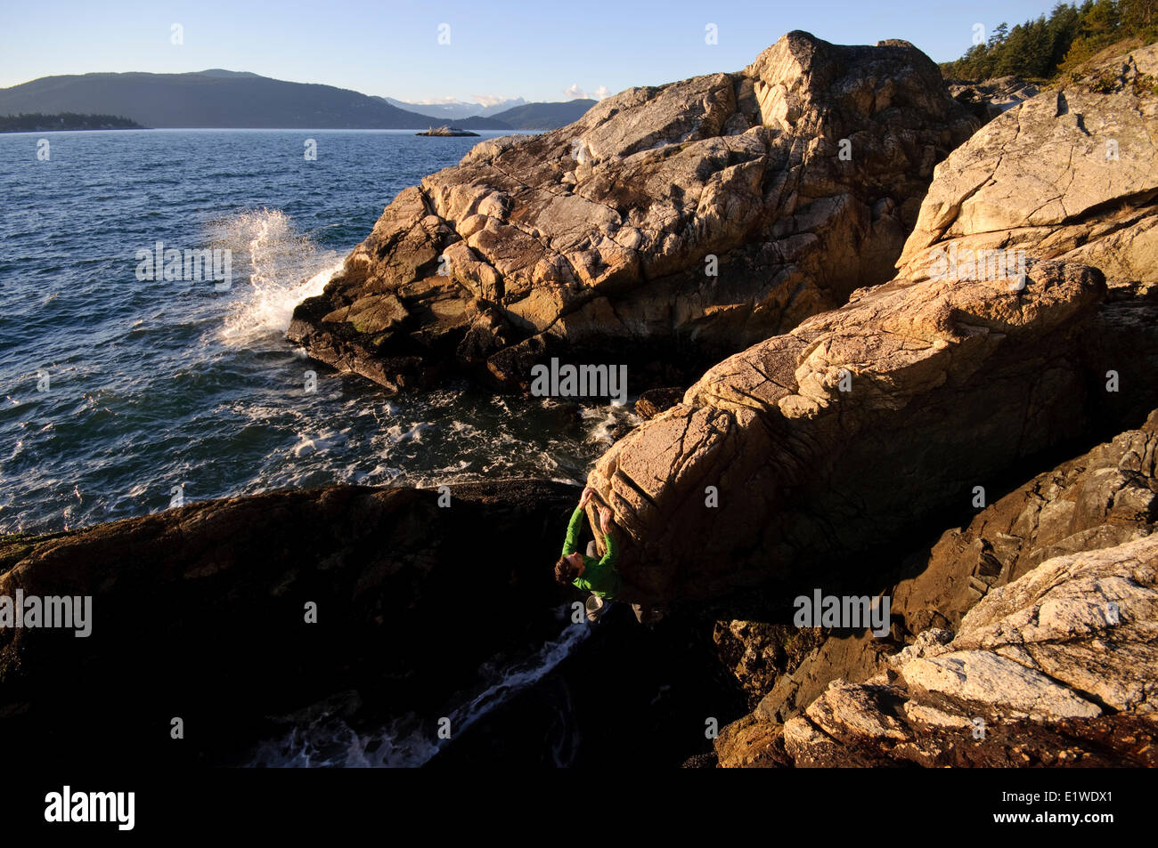 Rock climbing above the ocean at Lighthouse Park. West Vancouver, British Columbia, Canada Stock