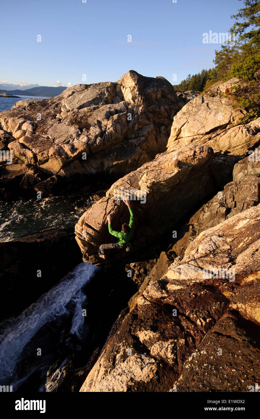 Rock climbing above the ocean at Lighthouse Park. West Vancouver, British Columbia, Canada Stock