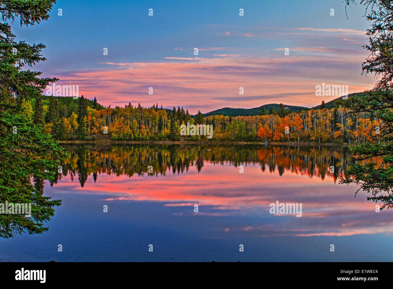 Sibbald Lake as seen in the fall at sunrise. Nice reflections of the sky and trees in the water. Stock Photo