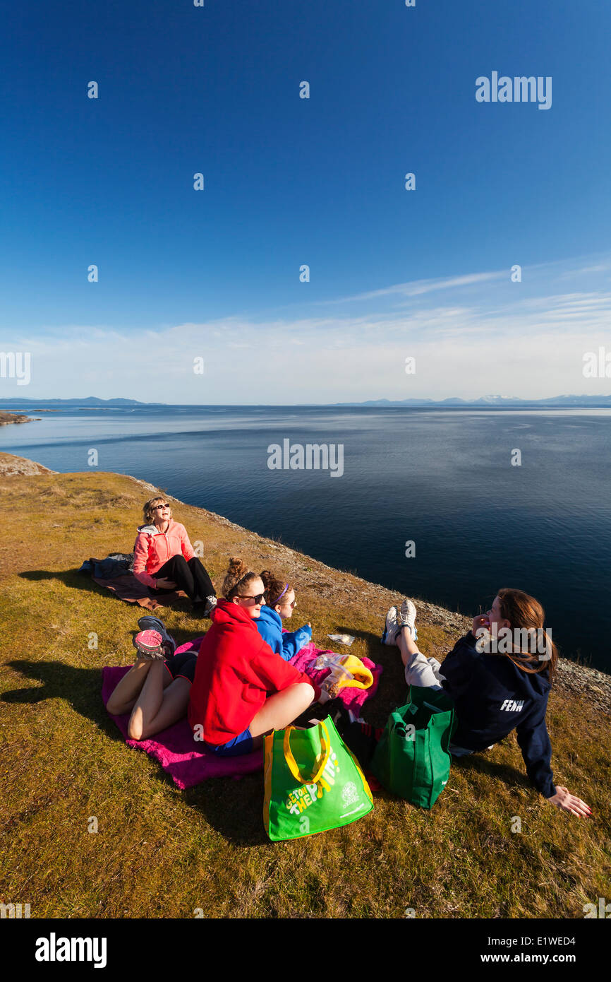 A family outing turns to laughter while having lunch along the cliffs Helliwell on Hornby Island.  Hornby Island Northern Gulf Stock Photo
