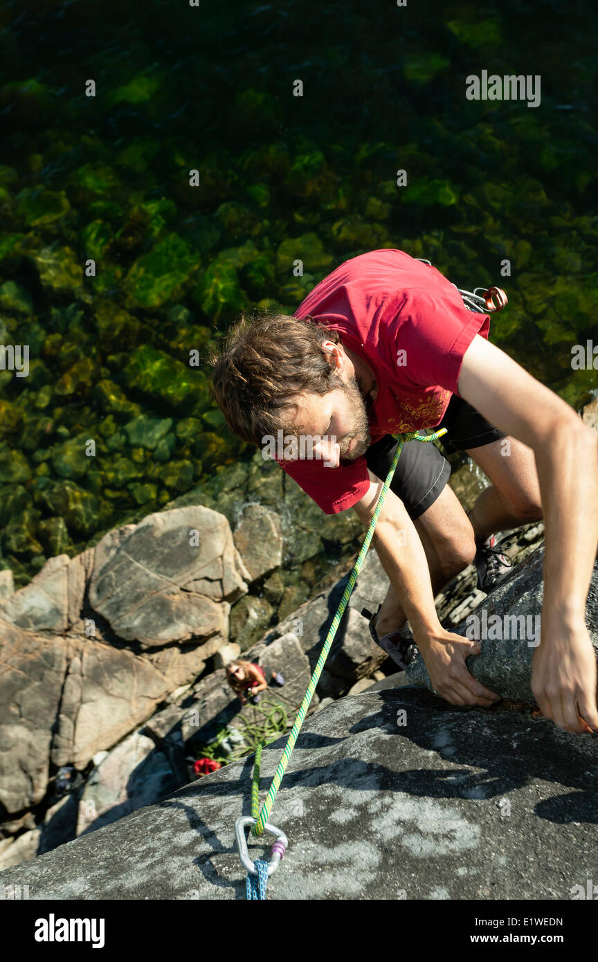 Jason Addy tops out on a route at Stillwater Bluffs a local climbing area sporting beautiful one pitch granite climbs just Stock Photo