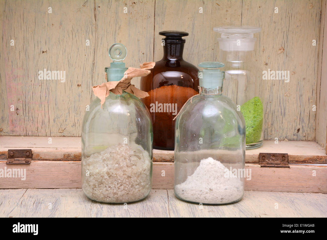 A set of chemical flasks with different chemical agents on an old shelf Stock Photo