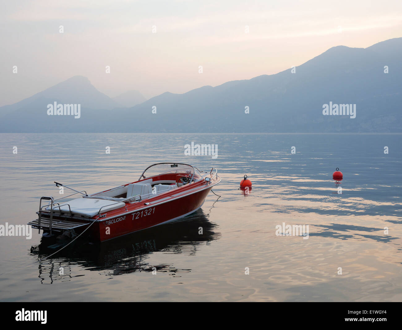 motorboat at misty sunset on Lake Garda, Italy Stock Photo