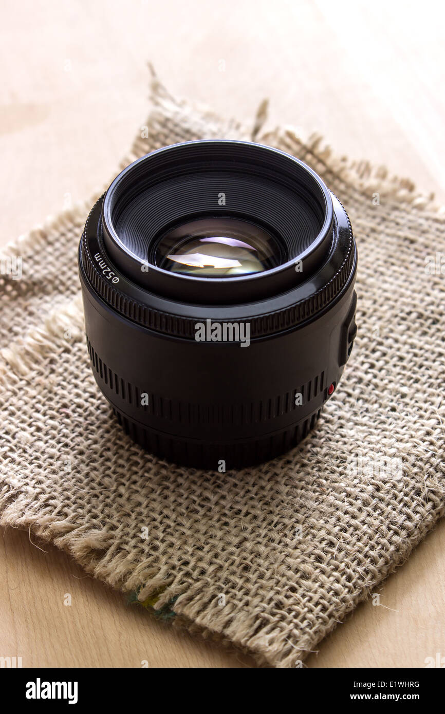 camera lens on the wooden table, backlit Stock Photo