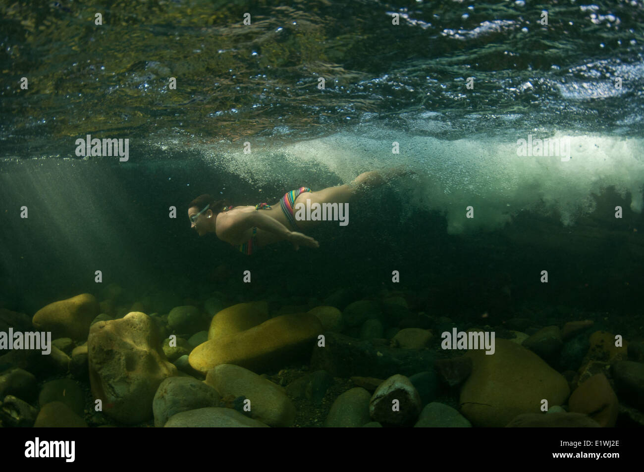 A girl swims underwater at Angel Falls near Courtenay, BC Stock Photo