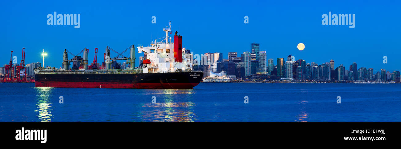 Moonset over Vancouver skyline with freighter, Vancouver B.C. Canada. Stock Photo
