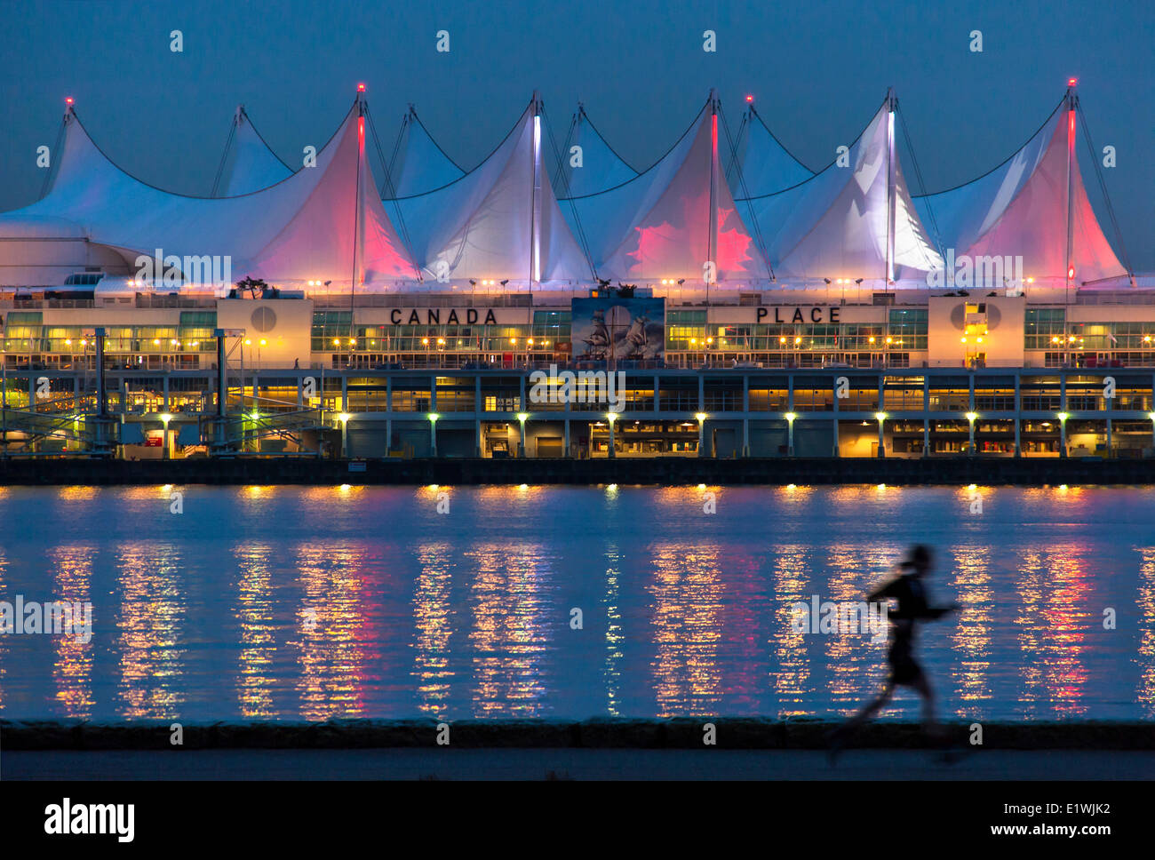 Women running infront of Canada Place at dawn, Vancouver, British Columbia, Canada Stock Photo