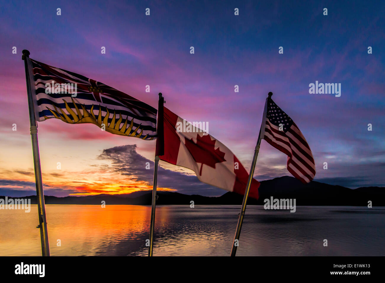 Flags at sunset over looking ocean Stock Photo