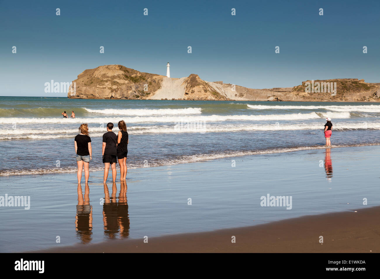 People enjoying the surf at Castlepoint New Zealand on the South Pacific Ocean Stock Photo