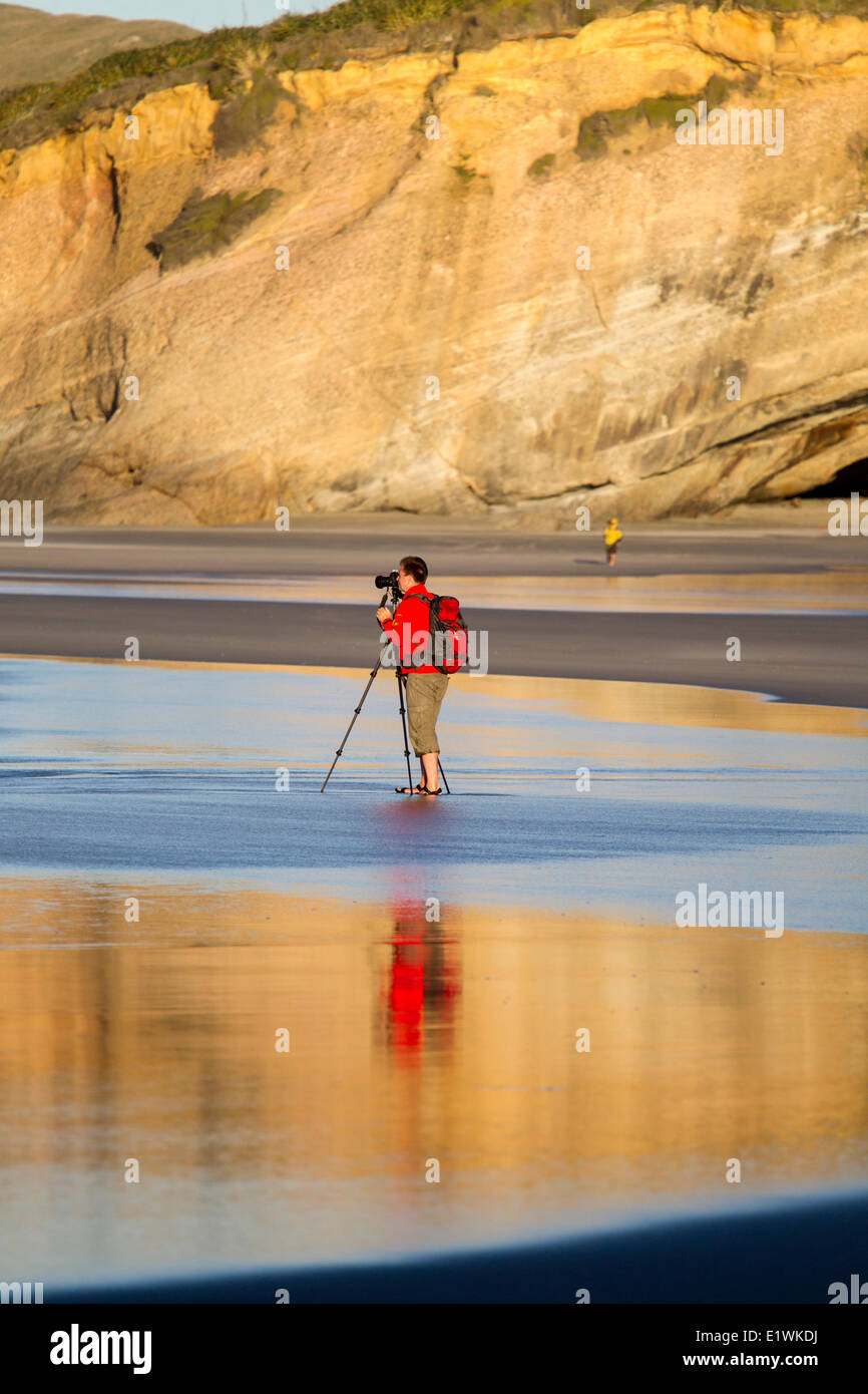 Photographing the rock formations at Wharariki Beach, New Zealand Stock Photo