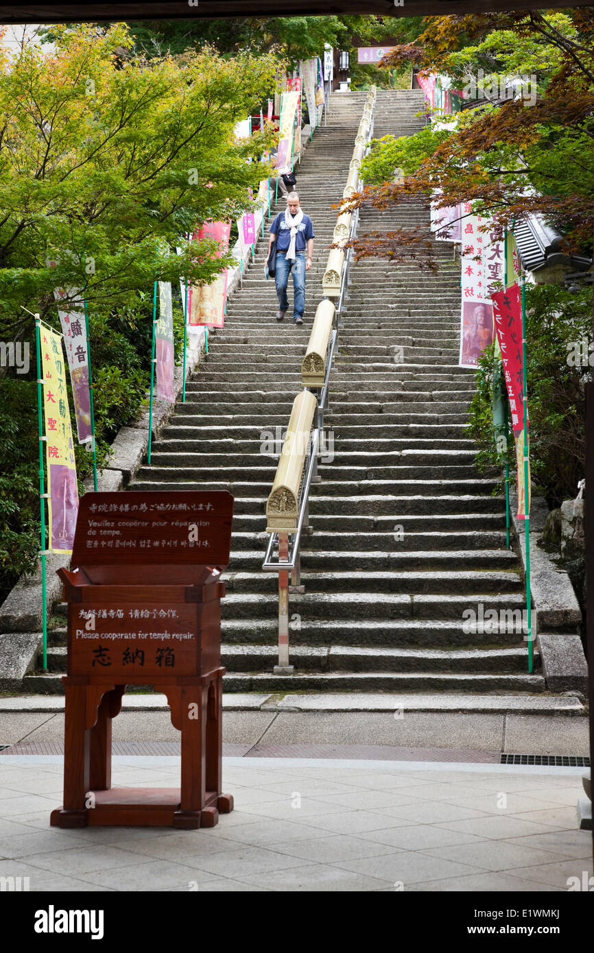 Just past the entrance (Niomon) to the Daisho-in temple is a flight of steps along which are prayer wheels inscribed with Buddhi Stock Photo