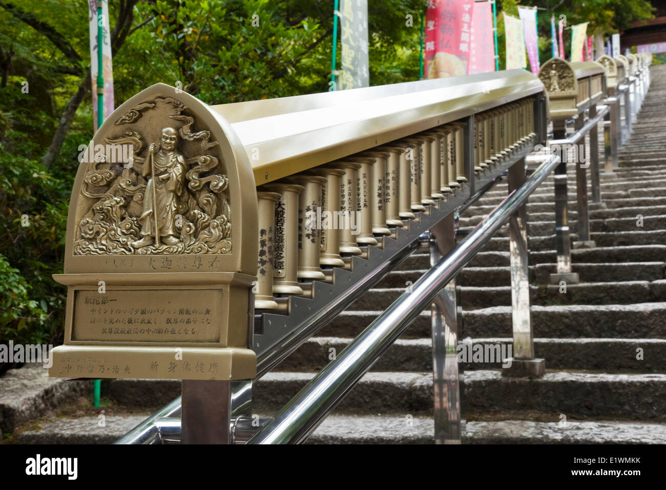 Just past the entrance (Niomon) to the Daisho-in temple is a flight steps along which are prayer wheels inscribed with Buddhist Stock Photo