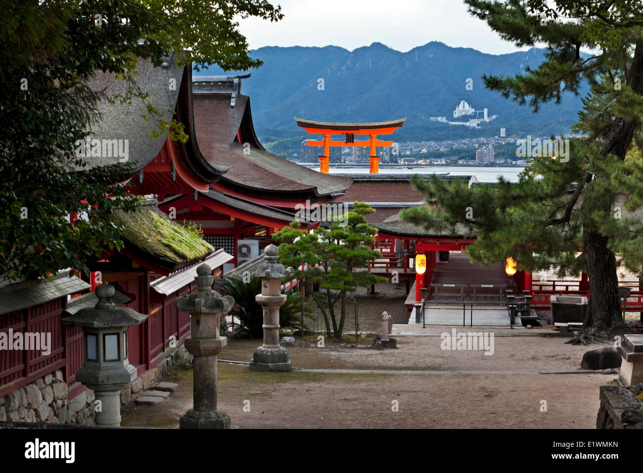 Grounds Itsukushima Shrine on Miyajima Island. In the background is the iconic giant torii gate which is erected in the middle Stock Photo