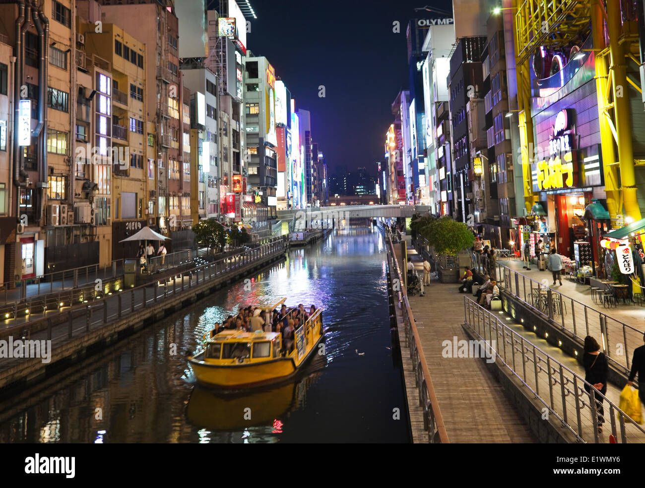 Tour boat cruising along the famous Dotombori canal in Osaka, Japan