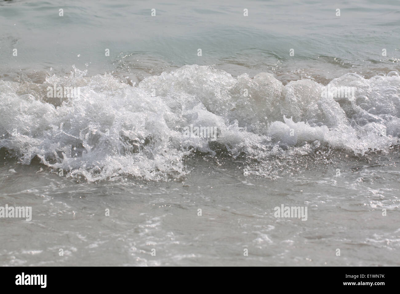 ocean wave rolling curling lip crashing on shallow sandbars. Stock Photo