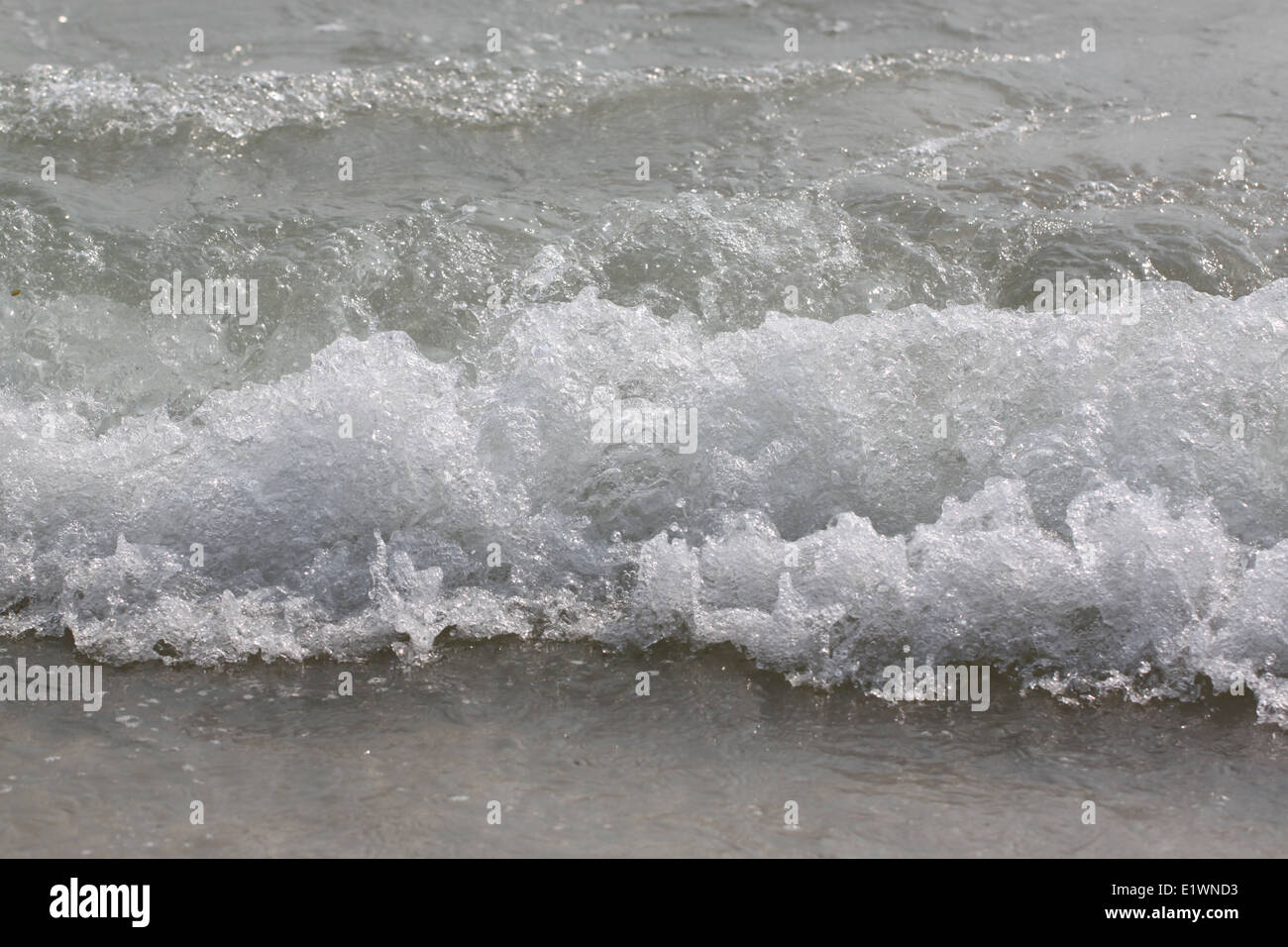 ocean wave rolling curling lip crashing on shallow sandbars. Stock Photo