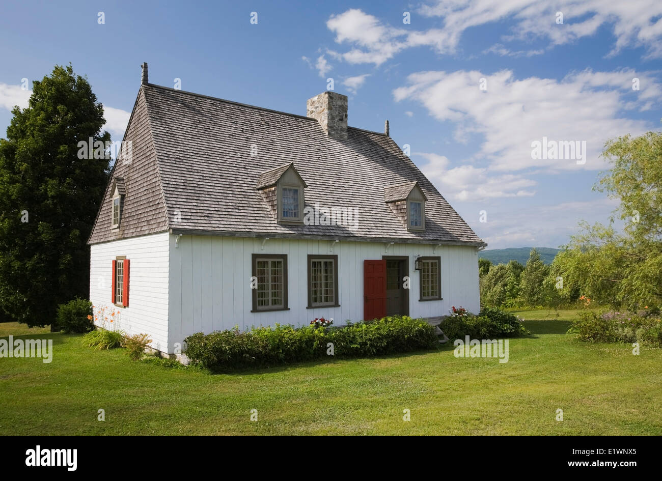 Old French regime cottage style residential home in summer Saint-Francois Ile d'Orleans Quebec Canada. This image is property Stock Photo