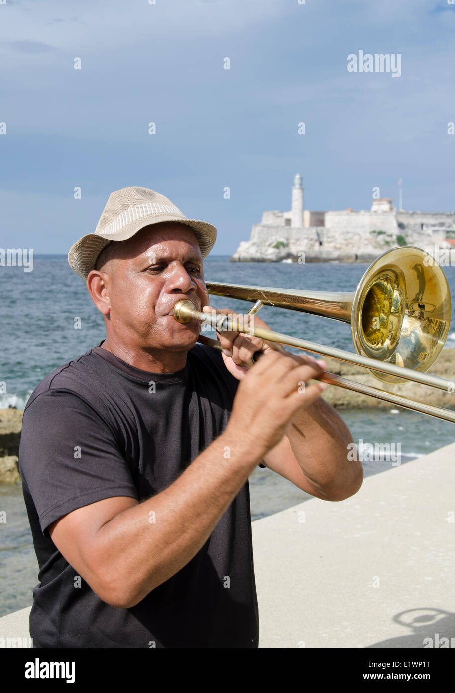 trombone playing musicians along the Malecon, Morro Castle in distance