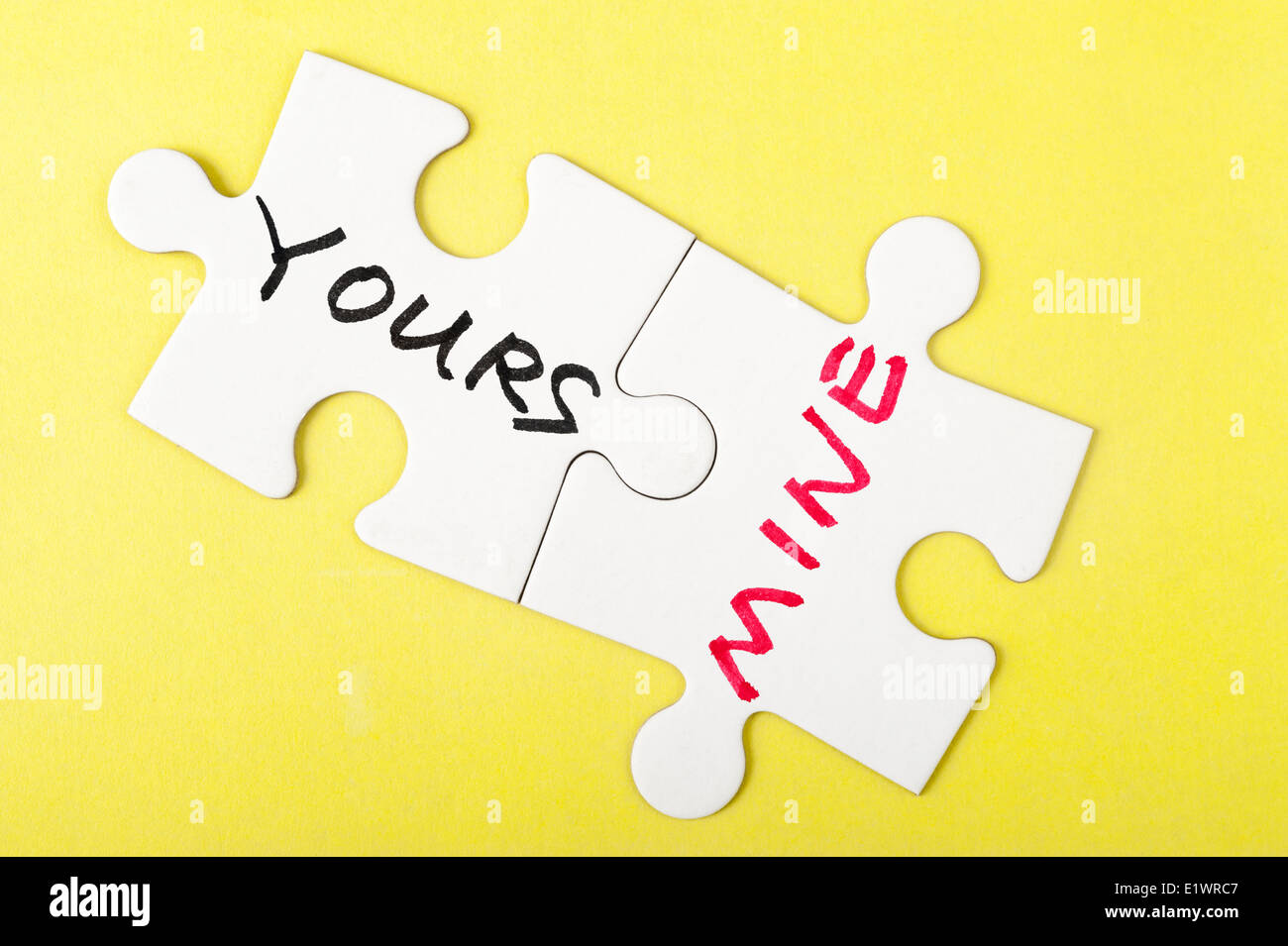 Yours or mine words on two pieces of jigsaw puzzle Stock Photo