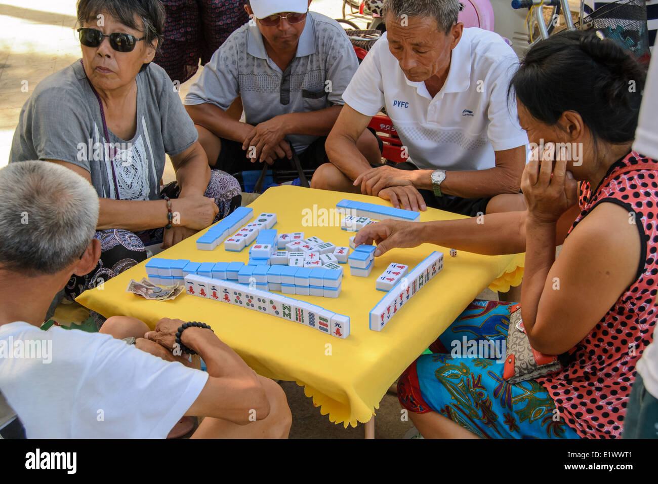 Some old people playing mahjong on the summer beach. Stock Photo