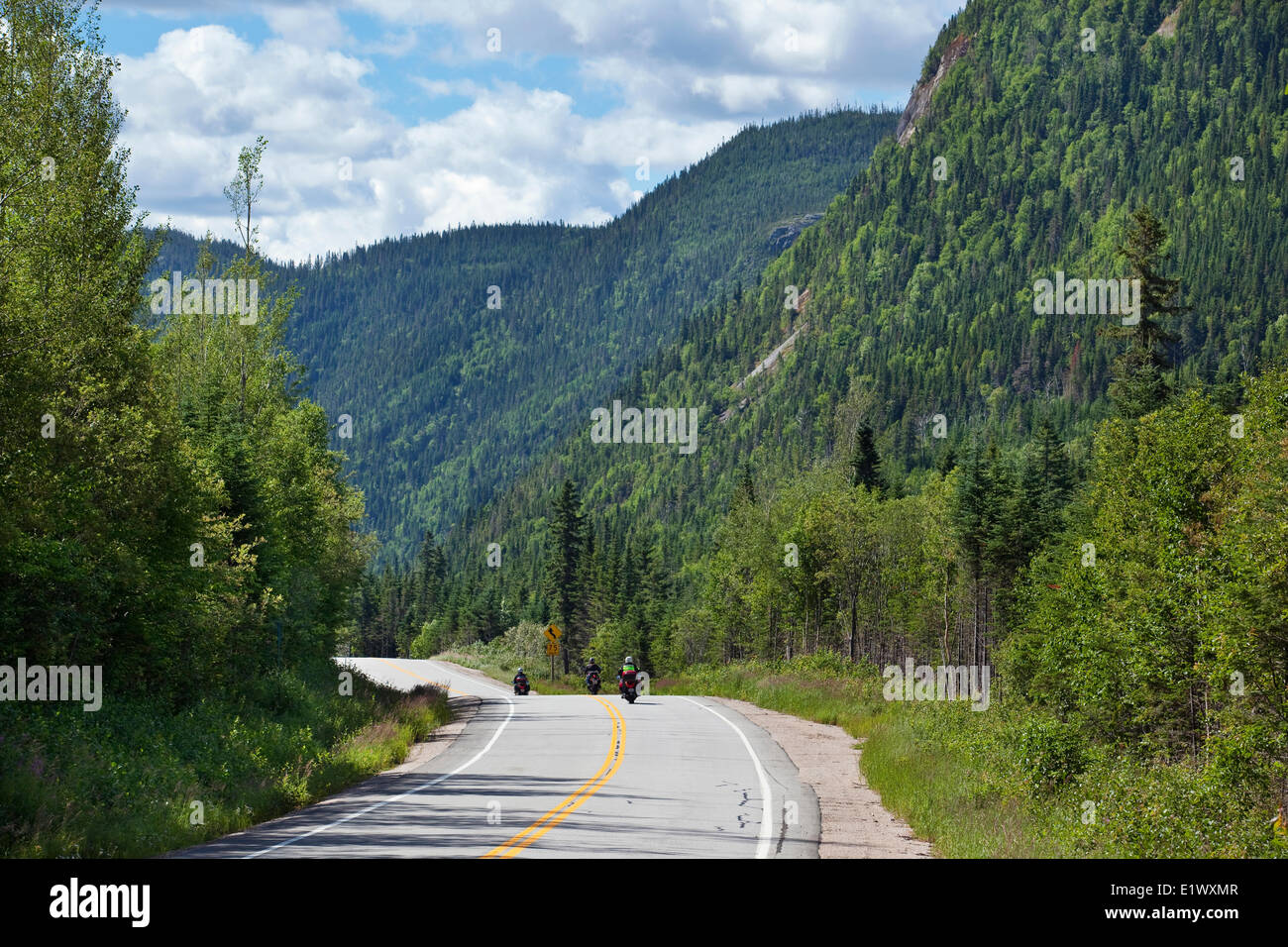 Motocyclists Touring On A Road That Cuts Through A Mountain Range In Stock Photo Alamy