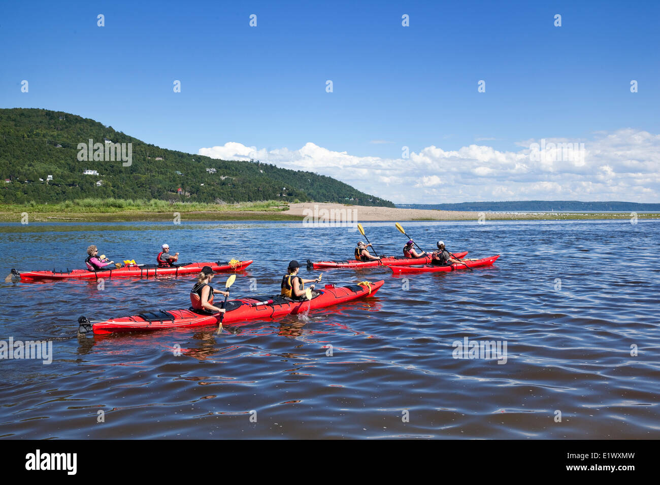 Kayakers and their guide on the Gouffre River, heading out for the open waters of the St. Lawrence River beyond. Baie-Saint-Paul Stock Photo