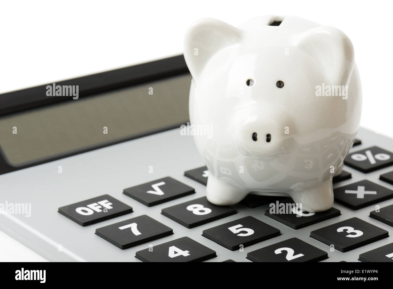 a white piggy bank on top of a calculator Stock Photo - Alamy