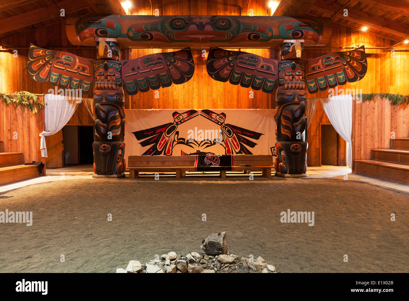 Beautifully carved totem poles traditional first nations architecture greet visitors to the big house at Klemtu.  Klemtu The Stock Photo