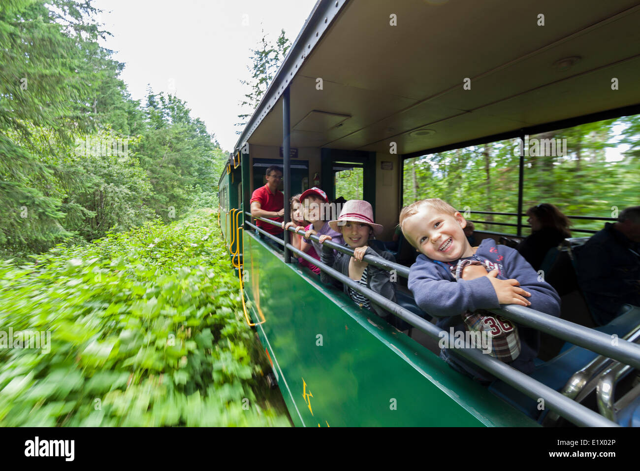Young children enjoy the open air passenger cars on the Alberni Pacific Steam Train enroute Port Alberni to the McLean Mill Stock Photo
