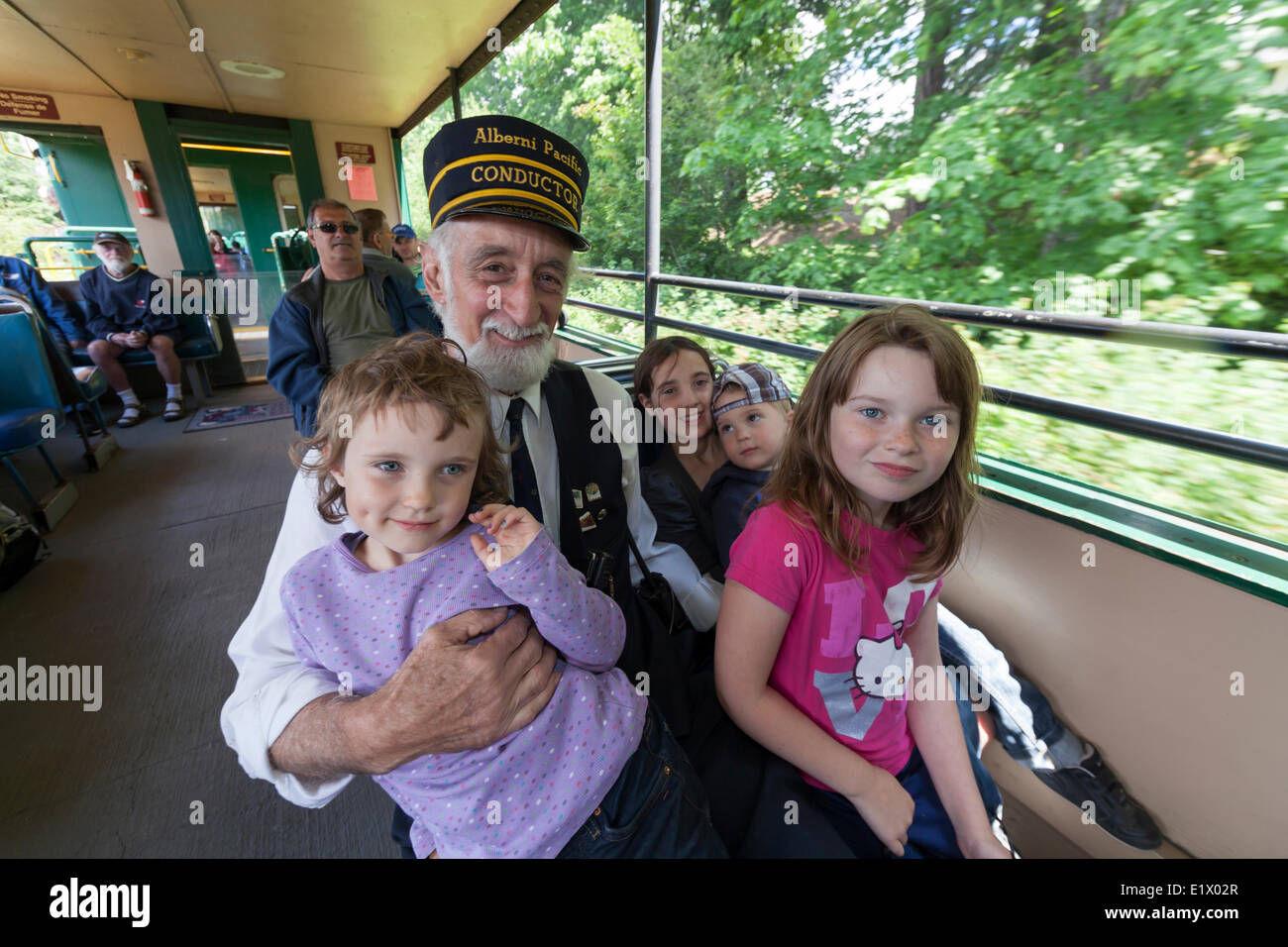 Children aboard the Alberni Pacific Steam Train ride with the train conductor while enroute to the McLean Mill tourist Stock Photo