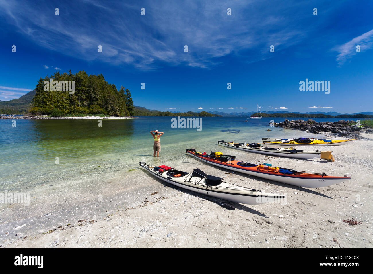 Kayaks line a white sandy beach on Hand Island located within the