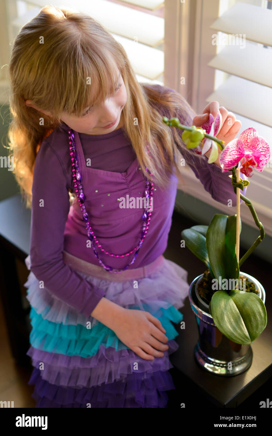 Young girl hanging out beside an orchid Stock Photo
