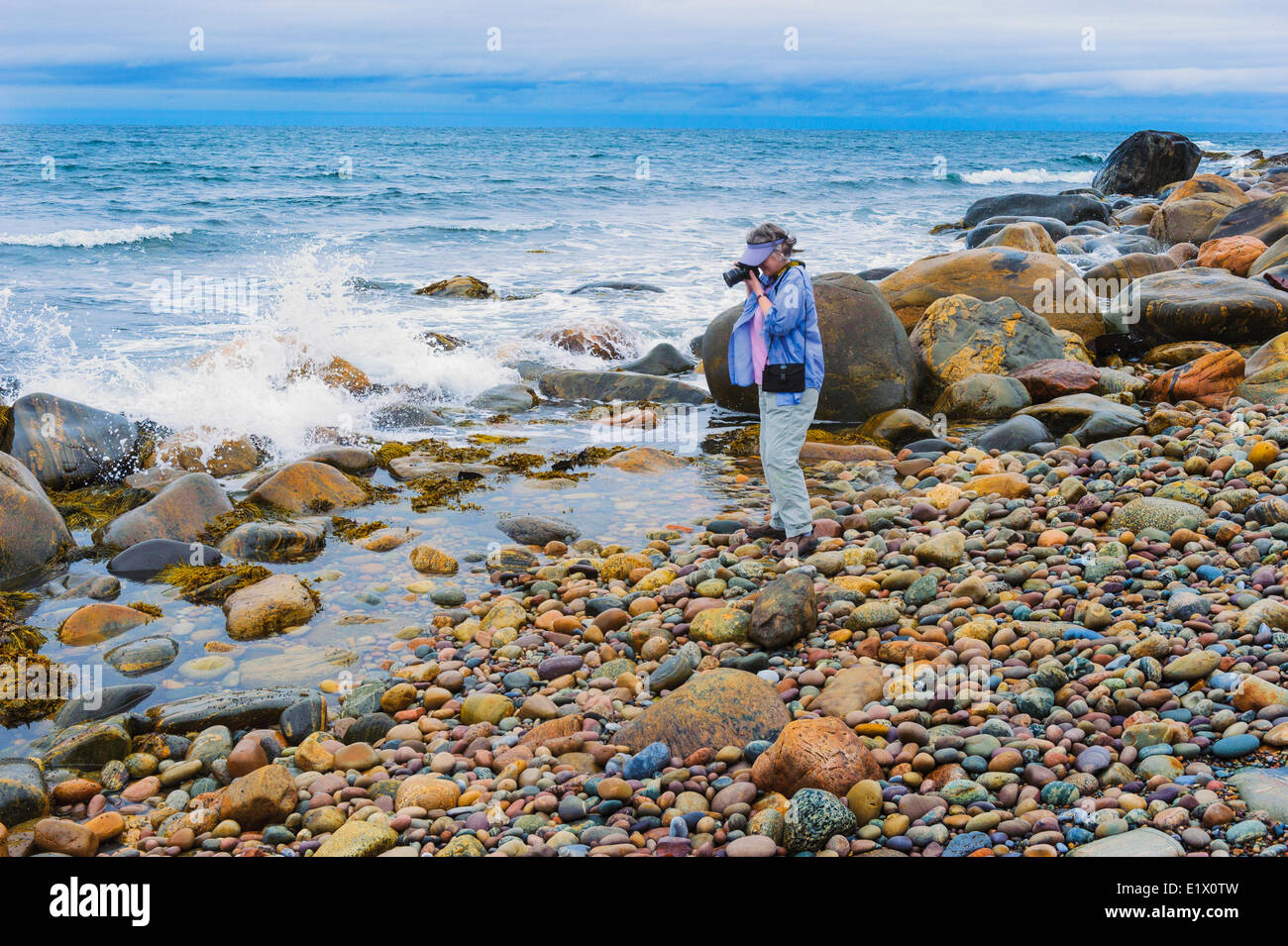 Tourist photographs incoming Atlantic Ocean waves in Gros Morne National Park, Newfoundland. Canada. MR Stock Photo