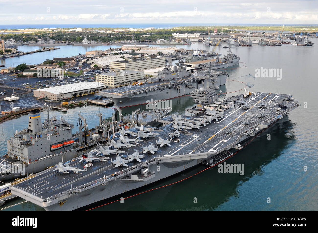 US Navy Nimitz-class aircraft carrier USS Ronald Reagan and the Wasp-class amphibious assault ship USS Bonhomme Richard sit alongside each other in Pearl Harbor while they prepare to embark for exercises in conjunction with Rim of the Pacific July 06, 2010 in Honolulu, Hawaii. Stock Photo