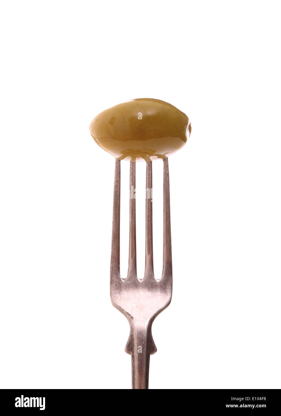 Huge green olive on fork, isolated, close up Stock Photo