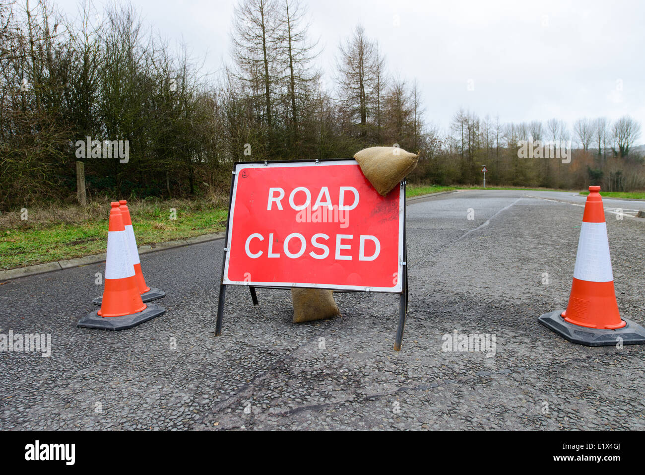 road closed sign after flooding with sandbags and cones Stock Photo